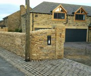 Dry-stone walls and pillars to a house in the village of Emley.