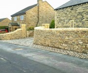 Dry-stone walls and pillars to a house in the village of Emley.